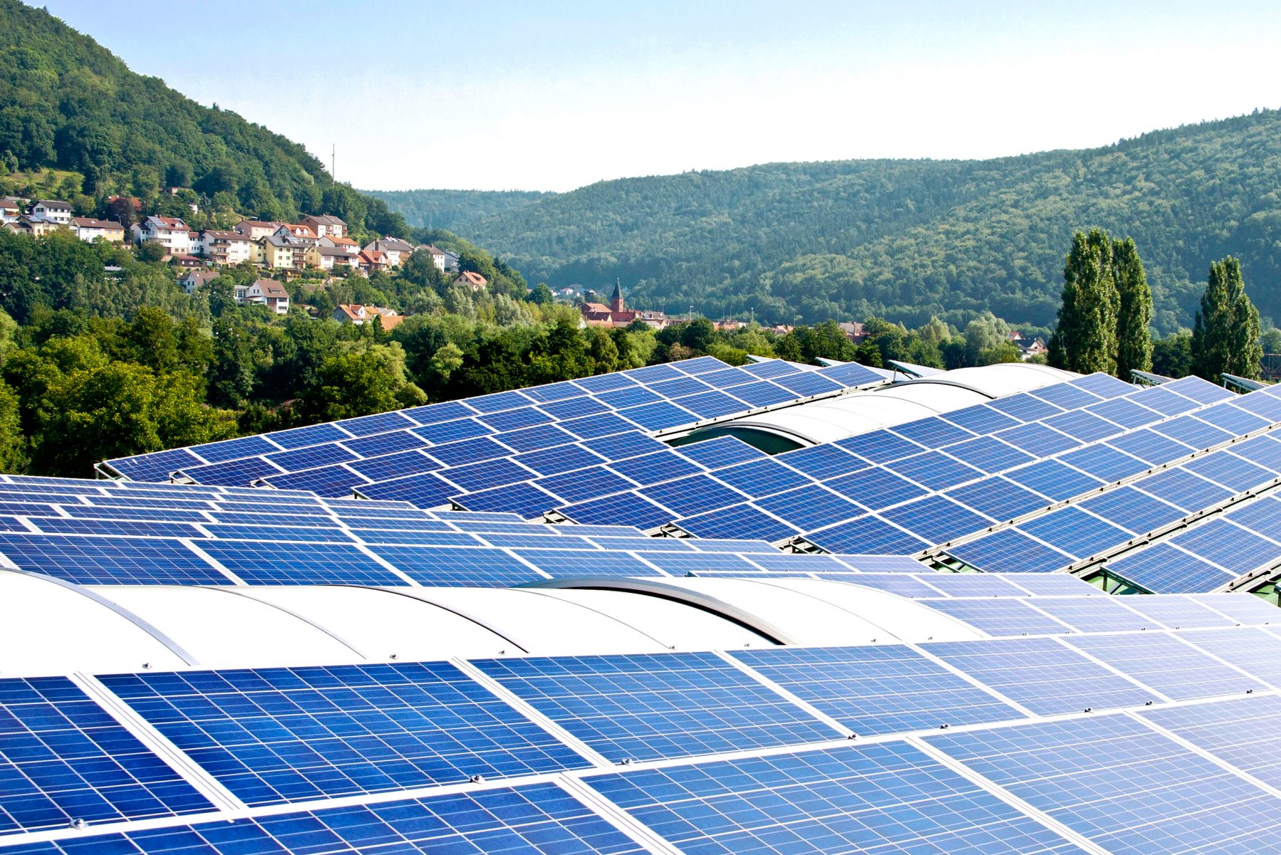 Solaranlage auf den Dächern I Ausblick darüber hinweg auf Ortschaft und Wald