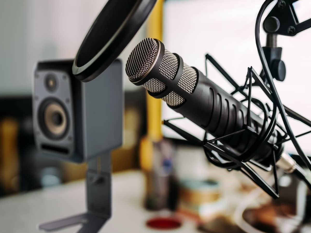Podcast Equipment: Miko + Popkiller + Halterung + Boxenstativ mit Lautsprecher auf einem Tisch